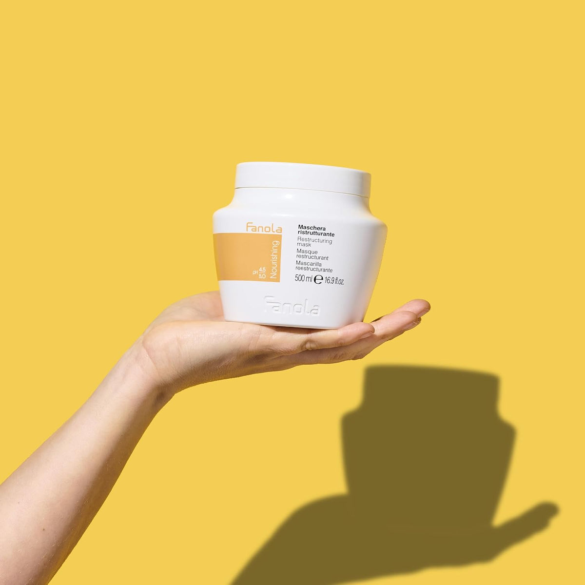 Pot de masque Fanola Nourishing 500 ml dans la main